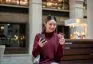 Asian,Woman,Holding,Credit,Card,Looking,At,Phone,While,Sitting